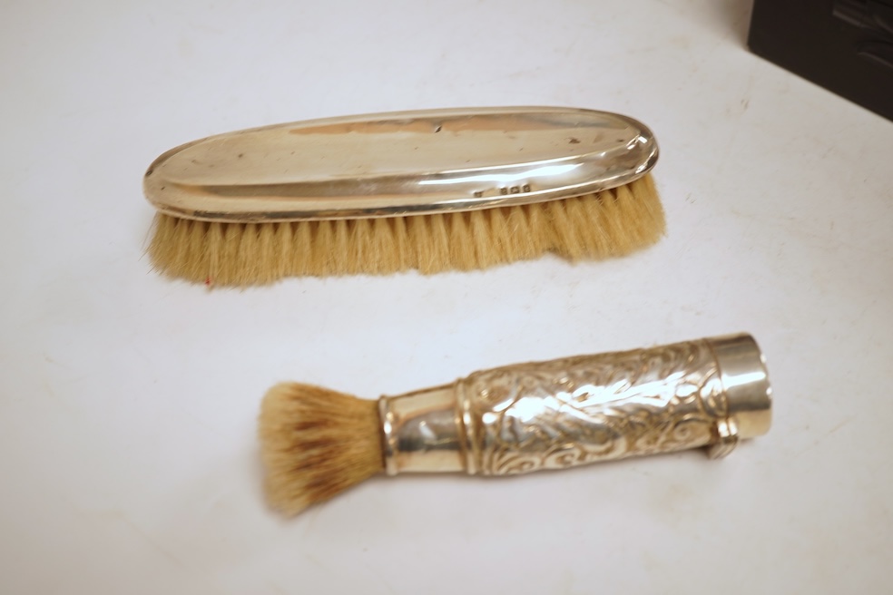 A small quantity of assorted silver including a Victorian sauceboat, London, 1851, length 12.6cm, a sugar bowl, a tea strainer on stand, mustard pot and ladle, three mounted brushes, a salt, pieced bonbon dish and a case